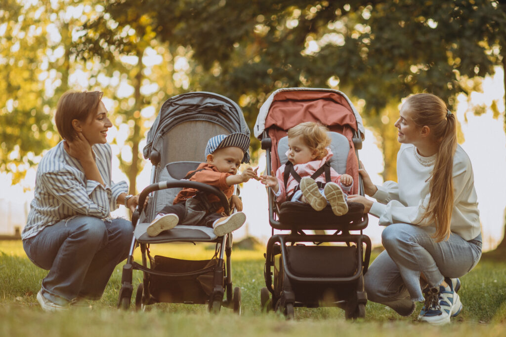 two-women-friends-walking-with-baby-prams-their-kids-park-1024x683.jpg